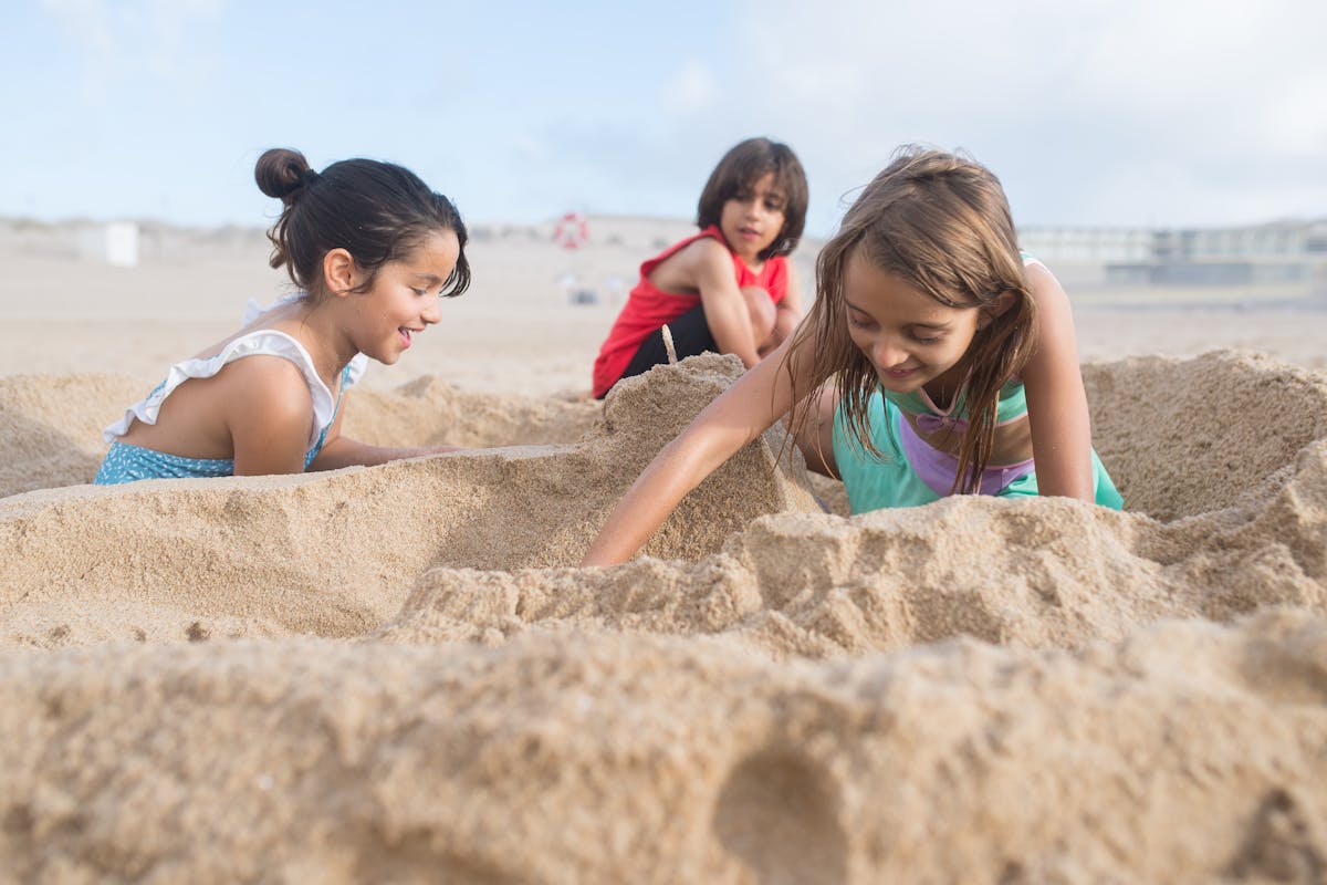 Children playing happily in the sand at the beach
