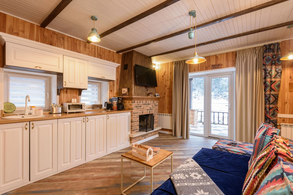 Cabin interior with a full kitchen and brick fireplace, the kitchen lodging that cuts a winter family budget