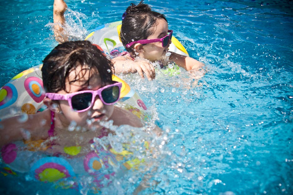 Kids swimming in an outdoor pool on a sunny family vacation day