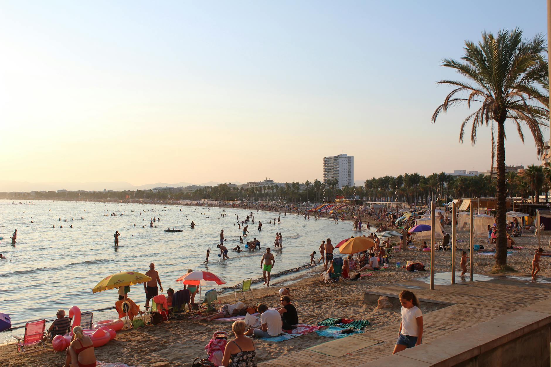 Sunny beach scene on the Spanish coast with beachgoers enjoying the Mediterranean