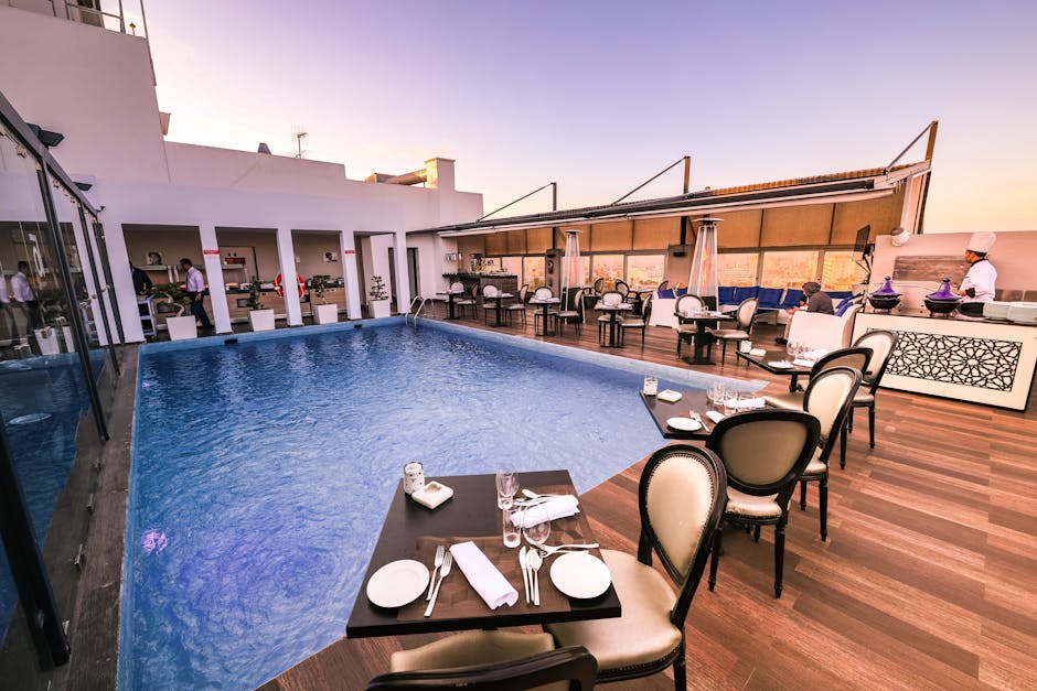 Rooftop dining area at a resort with pool and sunset views