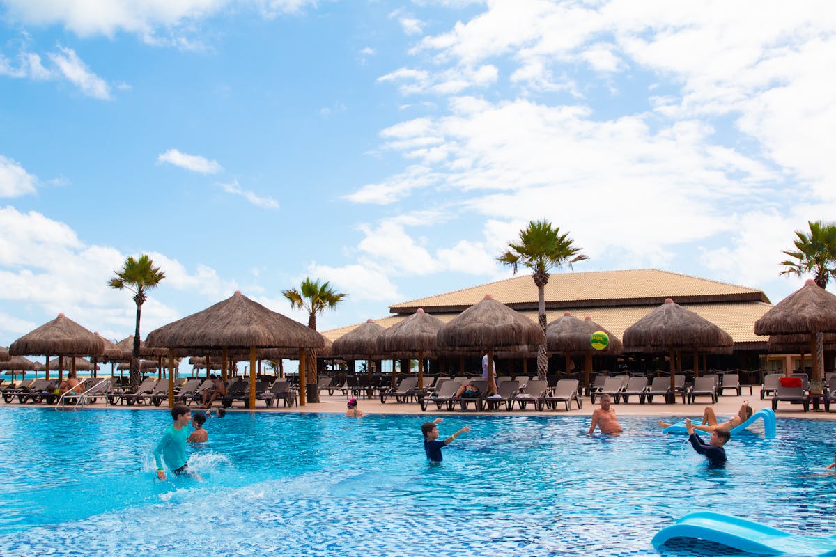 Families swimming and playing together in a tropical resort pool