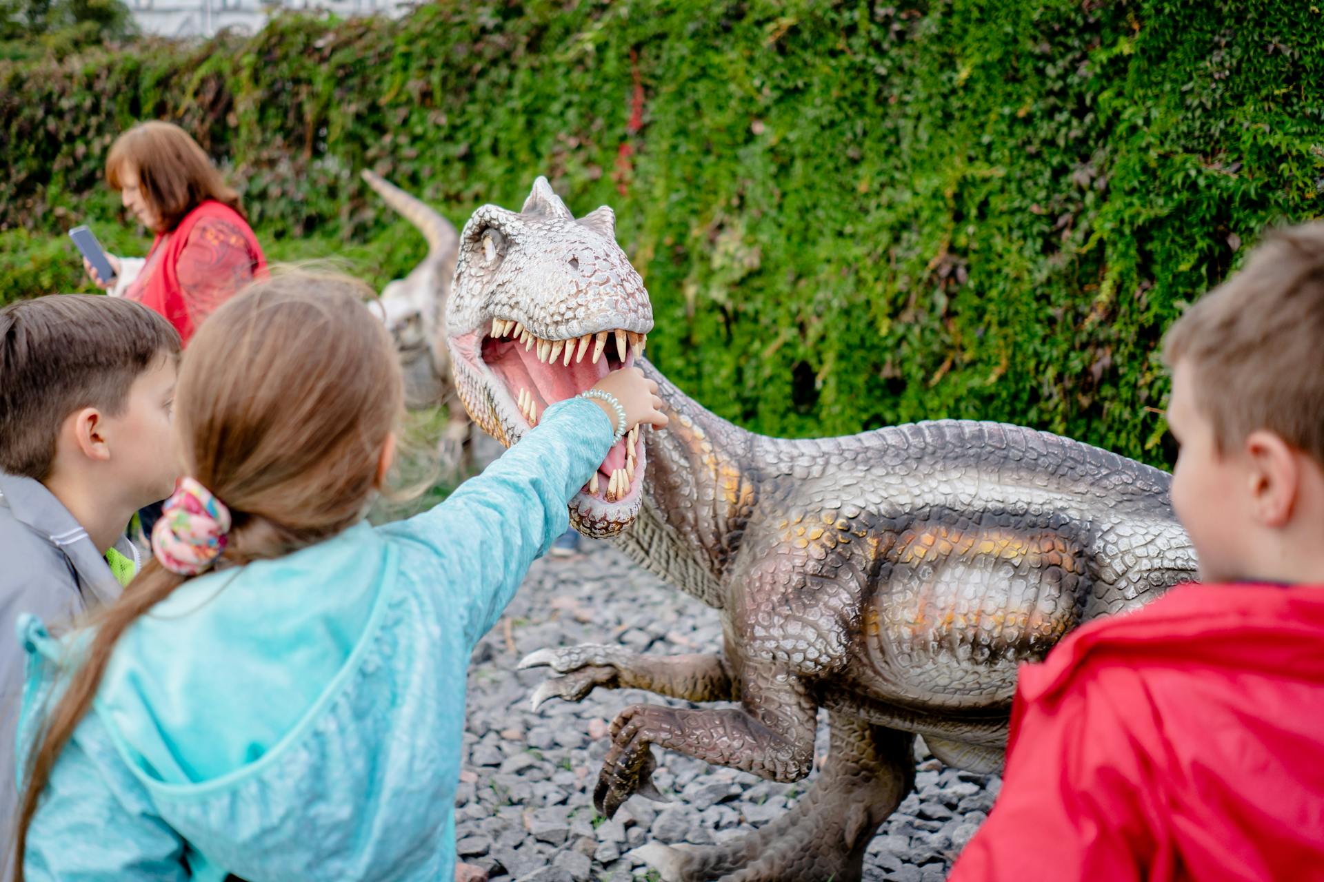Child interacting with a dinosaur exhibit at a natural history museum
