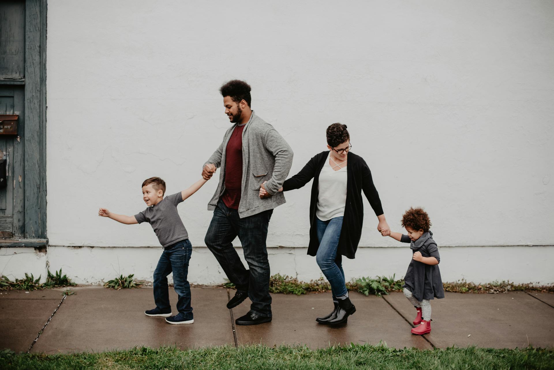 Family of four walking together along a city street on a sunny day