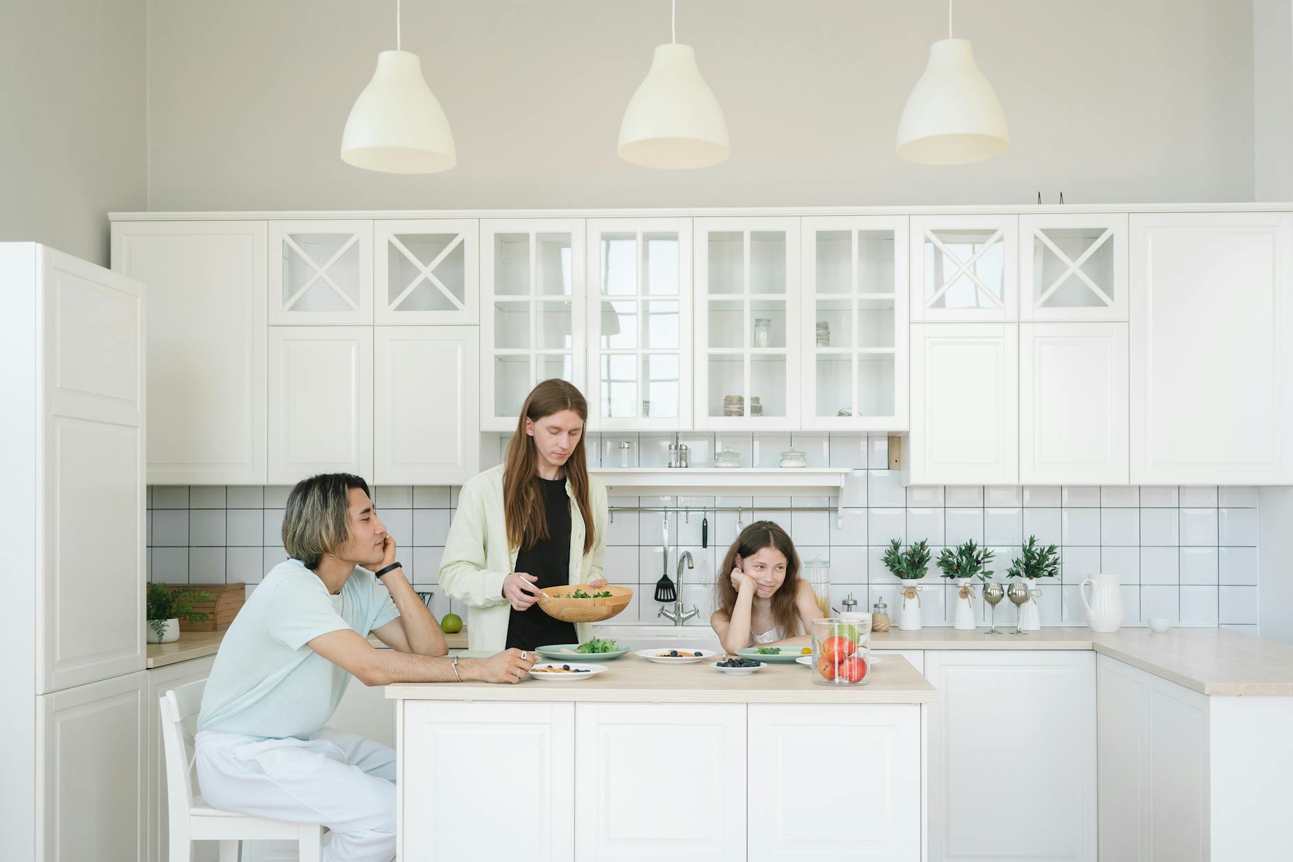 Family eating breakfast together at a counter in a bright modern kitchen during a vacation rental stay