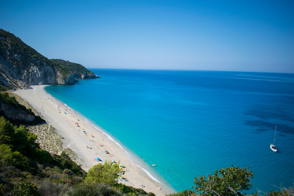 Turquoise beach with white sand and green cliffs on a Greek island