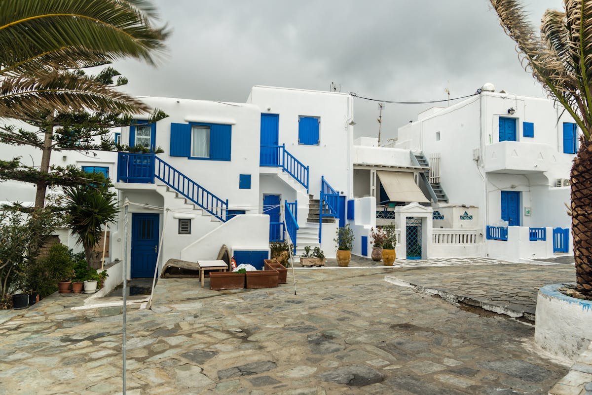 Traditional white and blue Cycladic houses with stone pathways on a Greek island