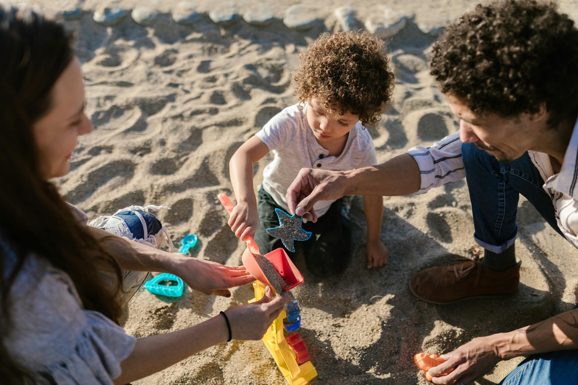 Parents and child building sandcastles together on a family beach vacation