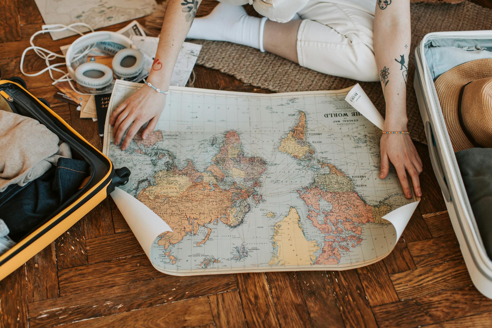 Person planning a summer vacation with a world map and suitcase