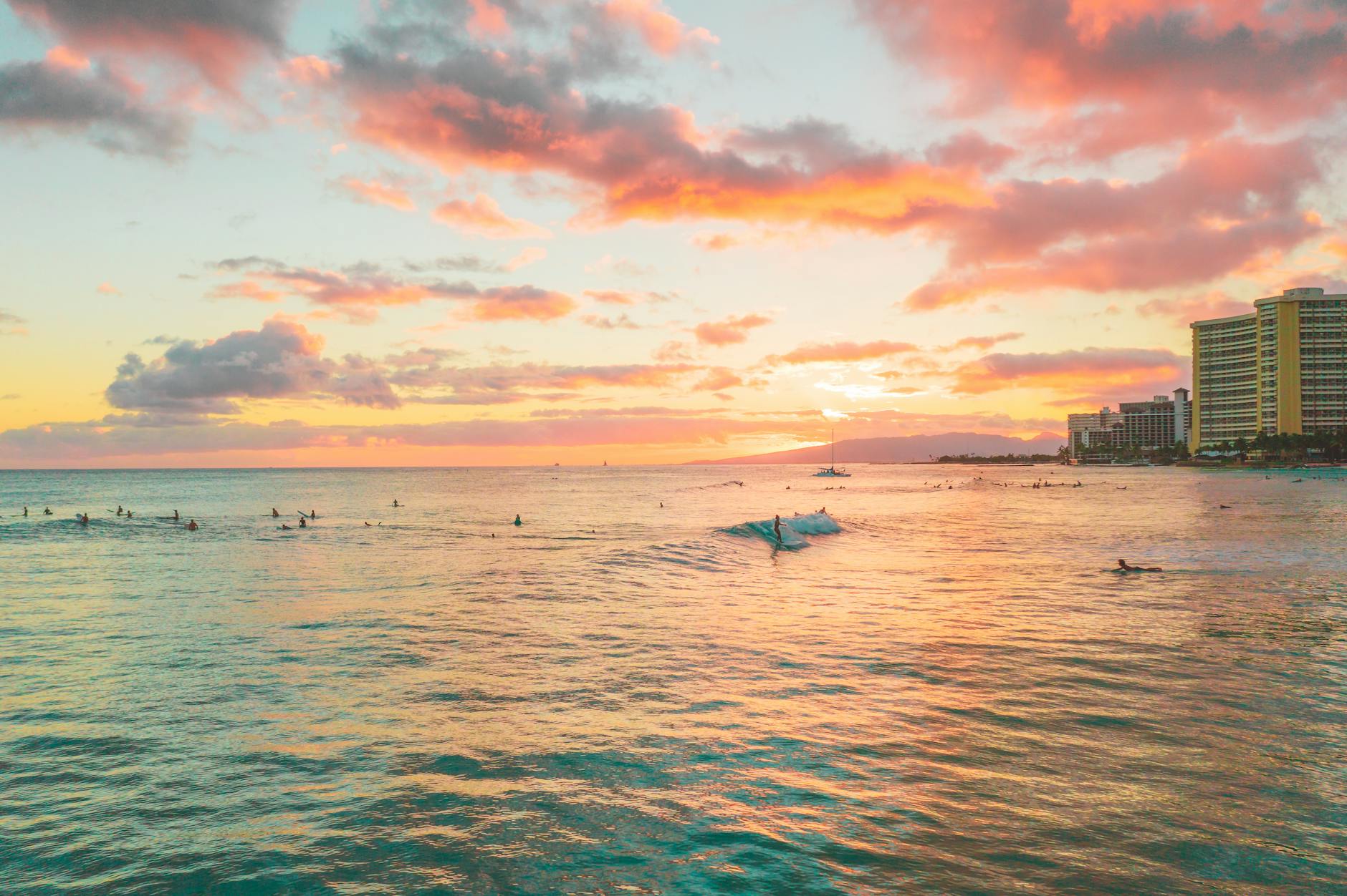 Waikiki Beach sunset with surfers in the warm Hawaiian water
