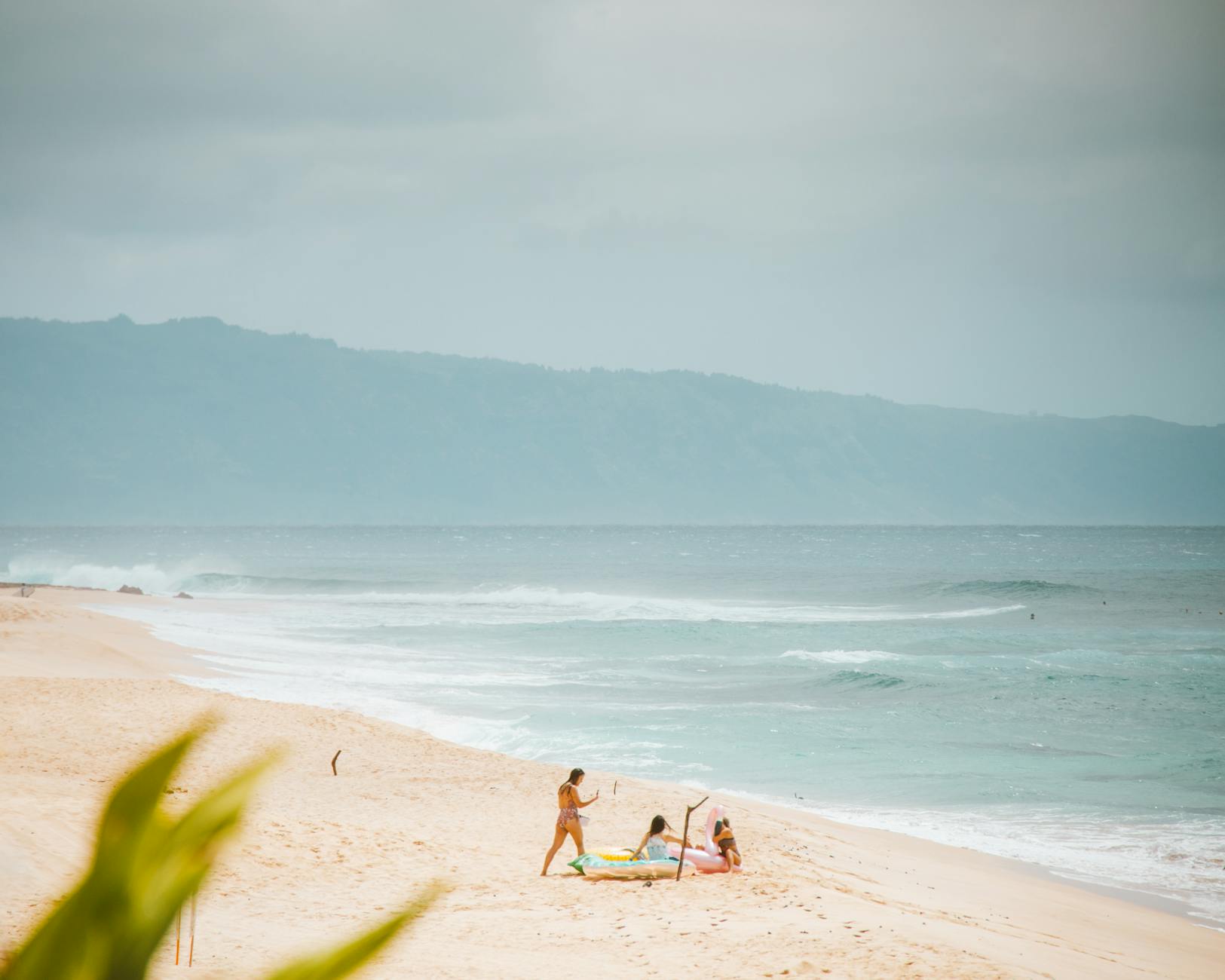 Family enjoying sandy beach at Pupukea on Oahu North Shore Hawaii