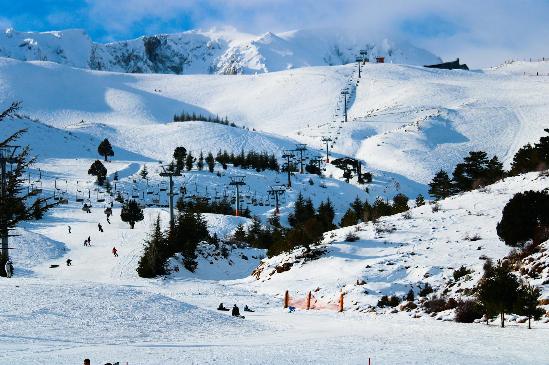 Ski resort with snowy mountain peaks and chair lifts on a clear winter day