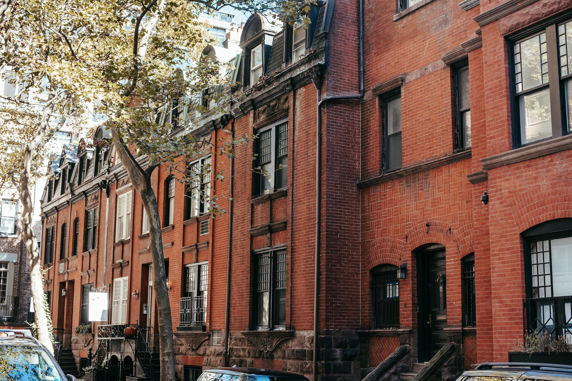Historic brick row houses on a sunny Boston street with autumn light