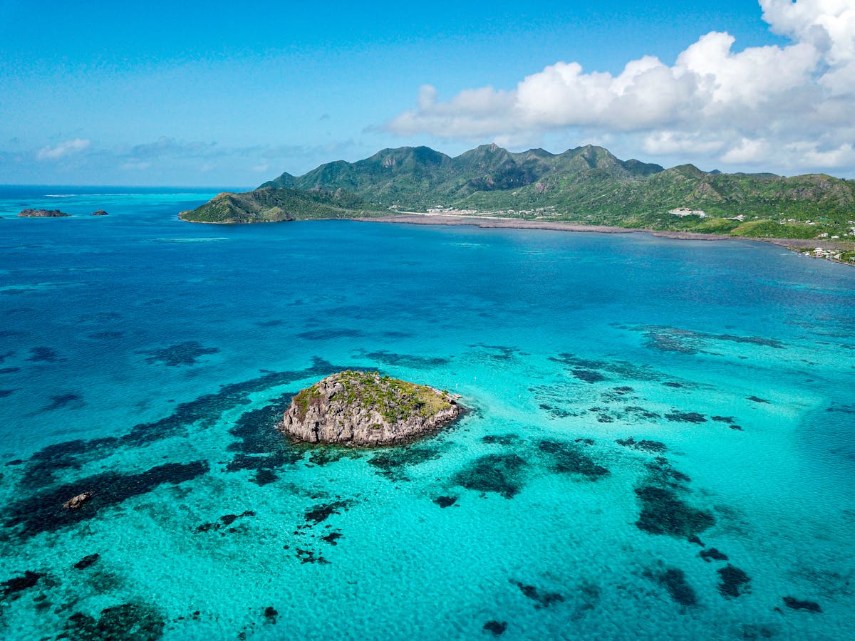 Aerial view of turquoise Caribbean waters and a rocky island coastline