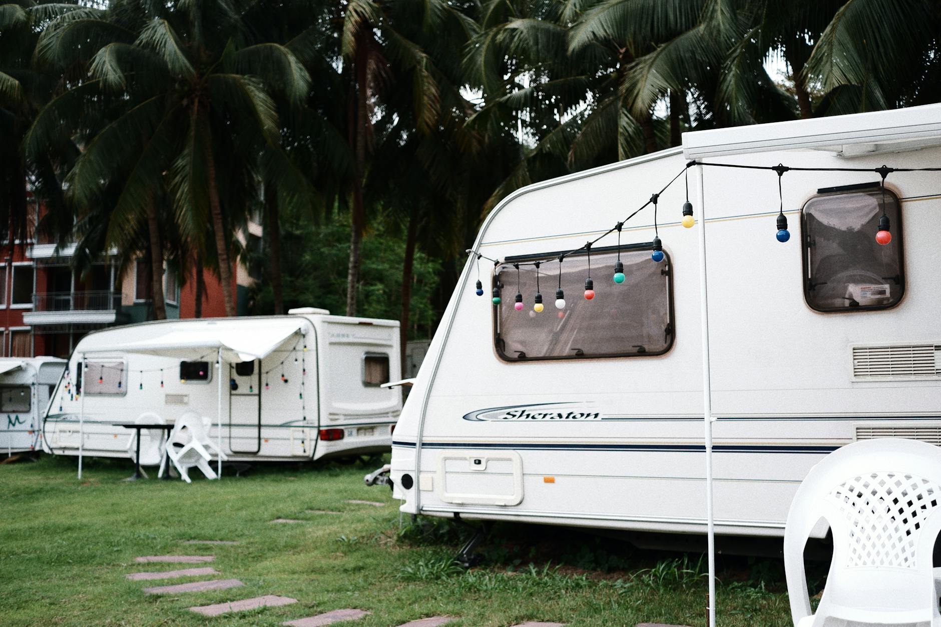 Holiday park caravans on a green campsite with outdoor seating area