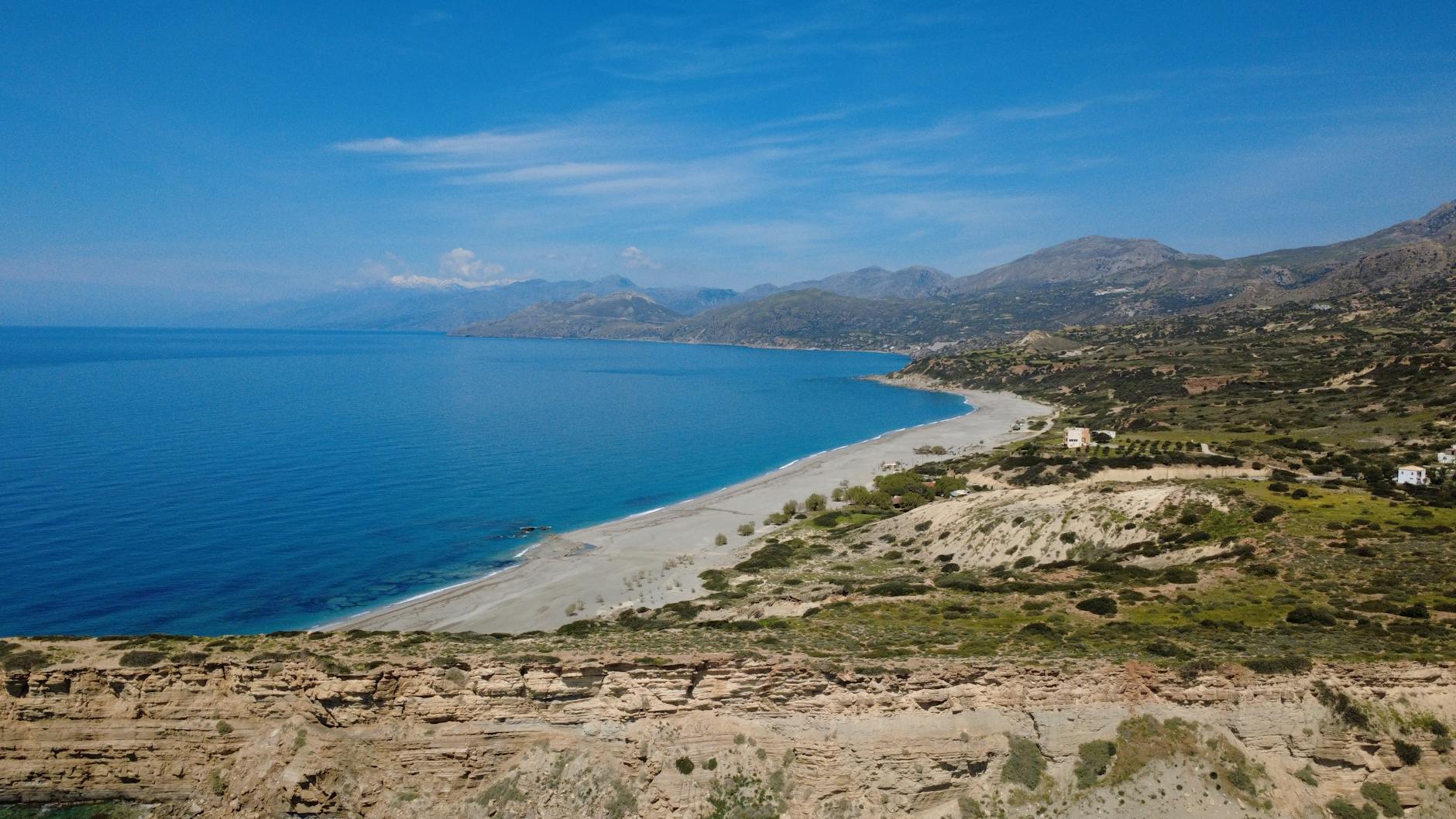 Long sandy Mediterranean beach and blue sea from the cliffs above a cheap family holiday resort