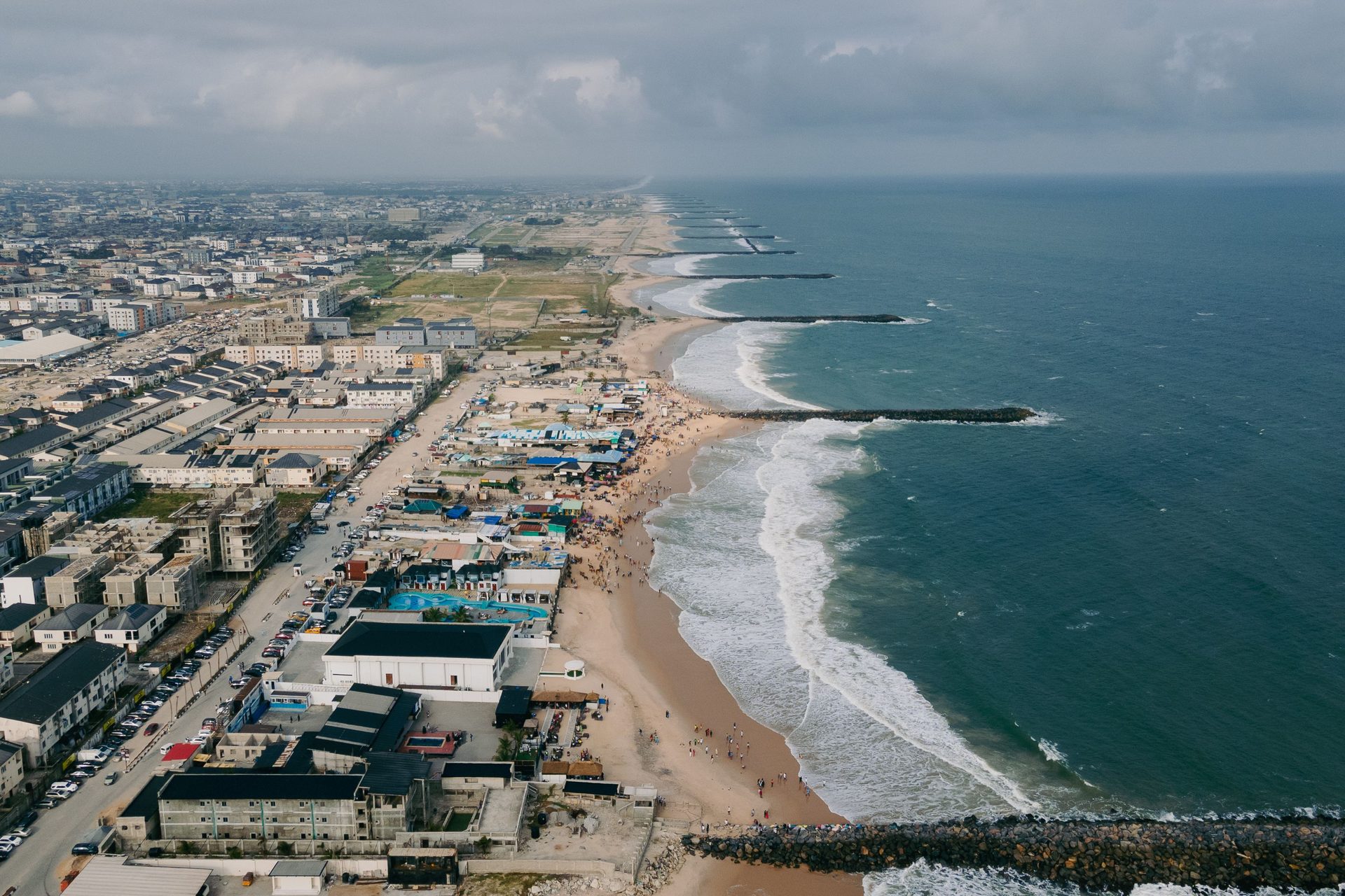 Aerial view of the Lekki coastline in Lagos, with a wide sandy beach, rock groynes and the Atlantic surf