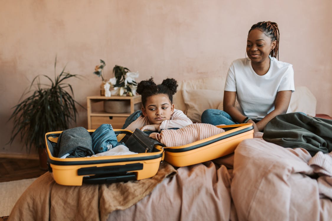 Mother and daughter packing suitcase together for family vacation