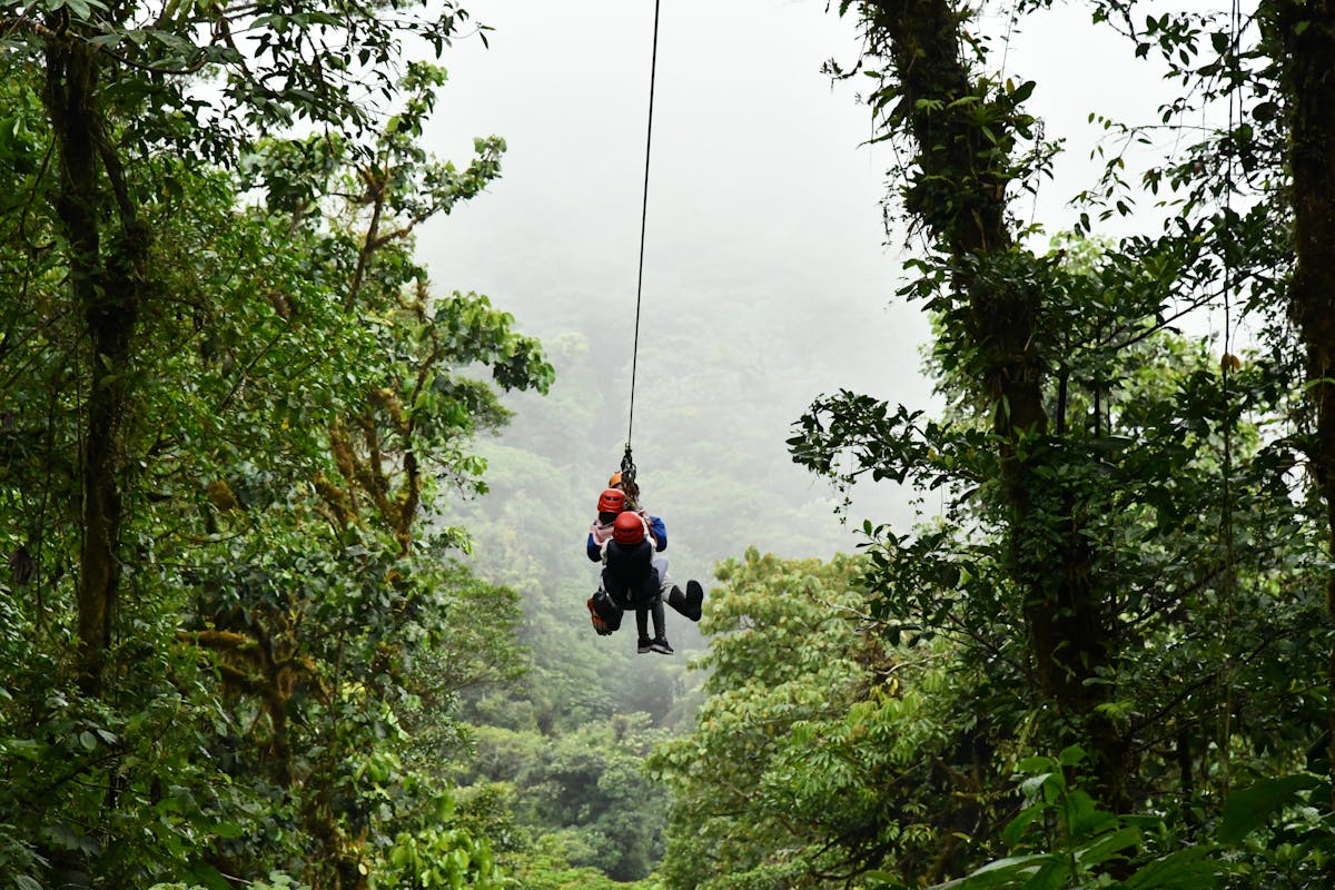 Family zip-lining through tropical forest canopy similar to Costa Rica adventure