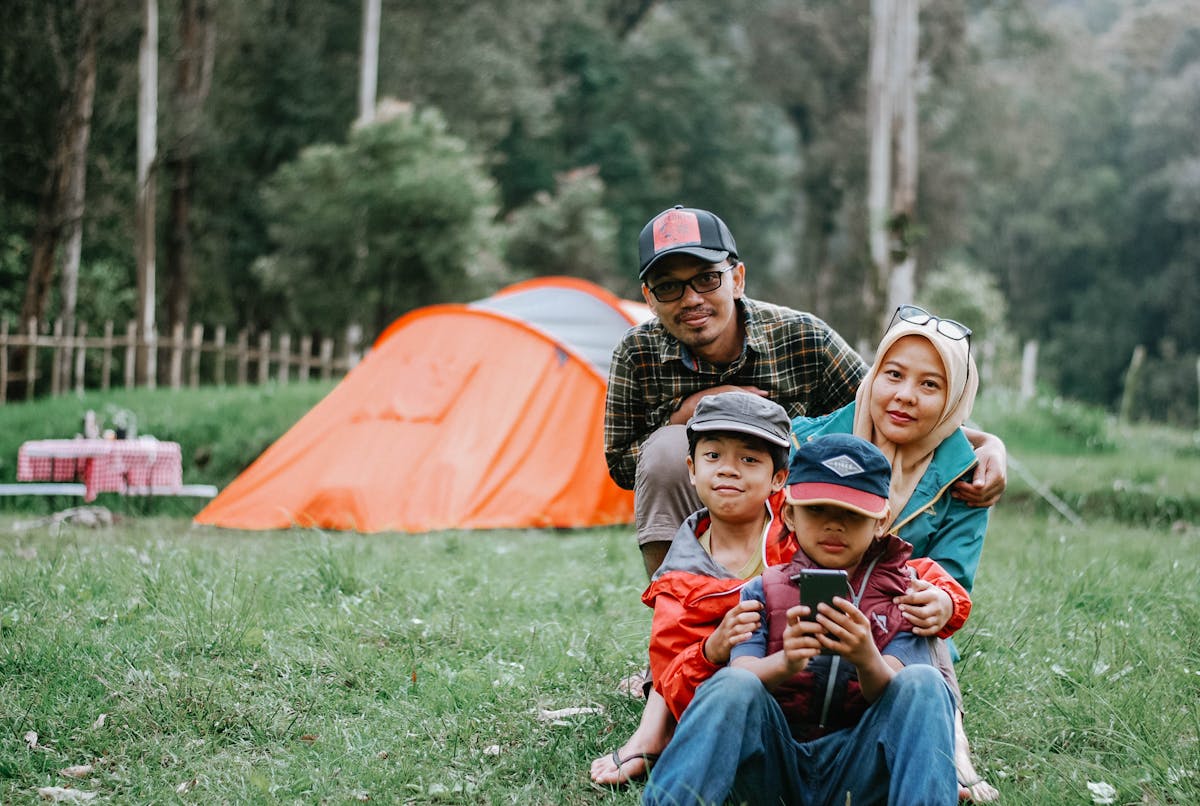 Family enjoying a camping adventure in a tranquil forest setting