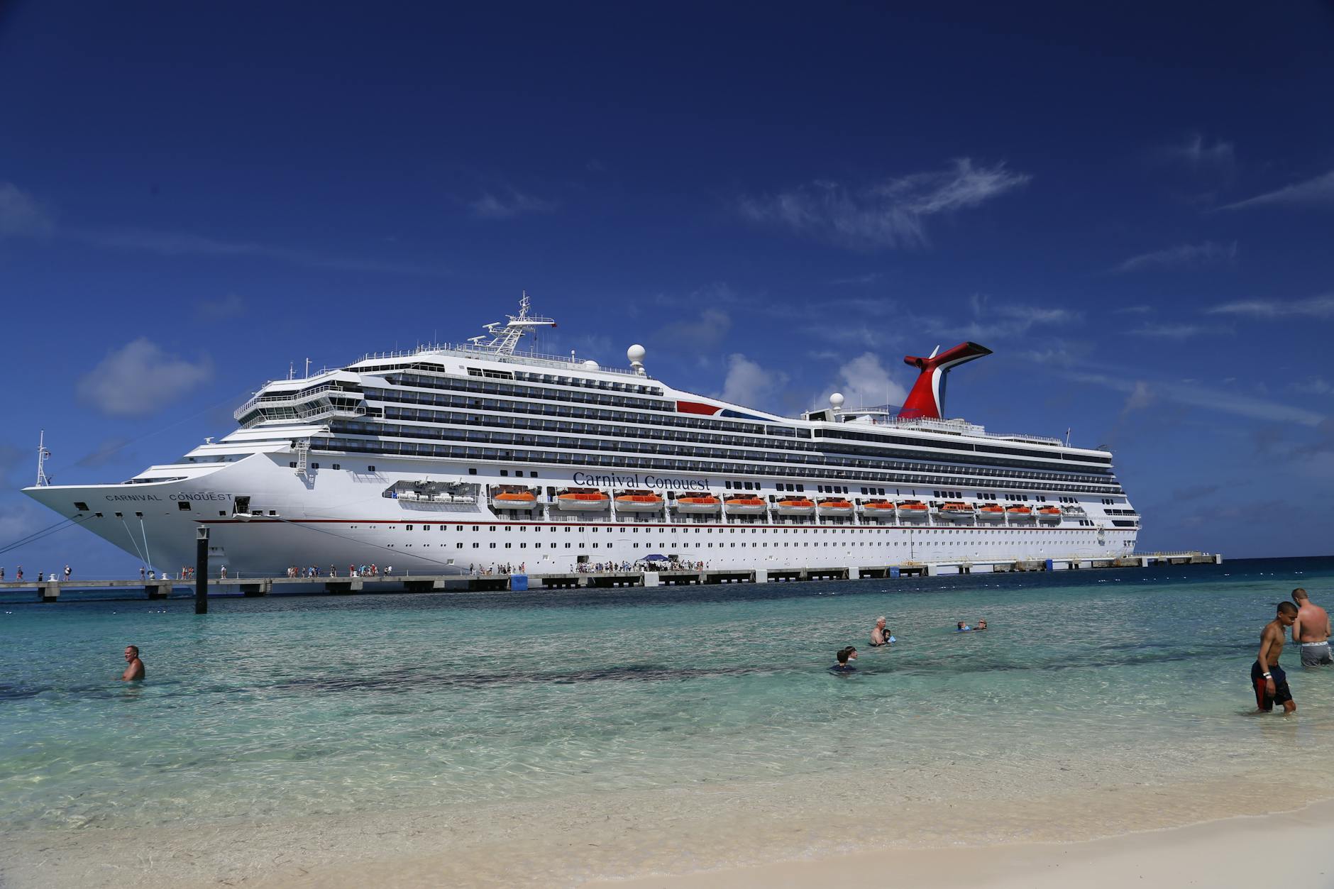Cruise ship anchored near tropical turquoise beach with clear blue water