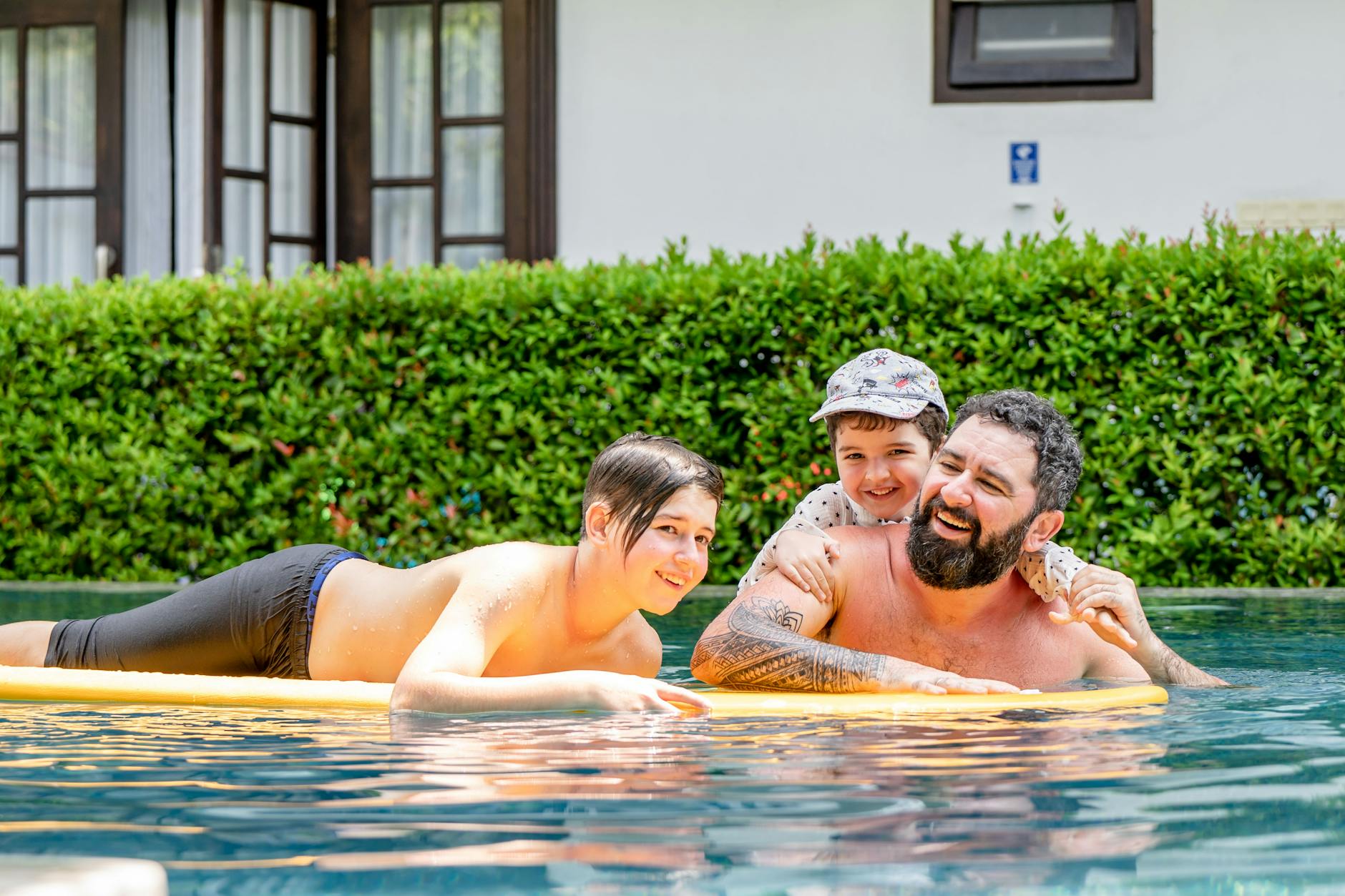 Family in pool float laughing showing the cruise-leg family pool kids club daily rhythm