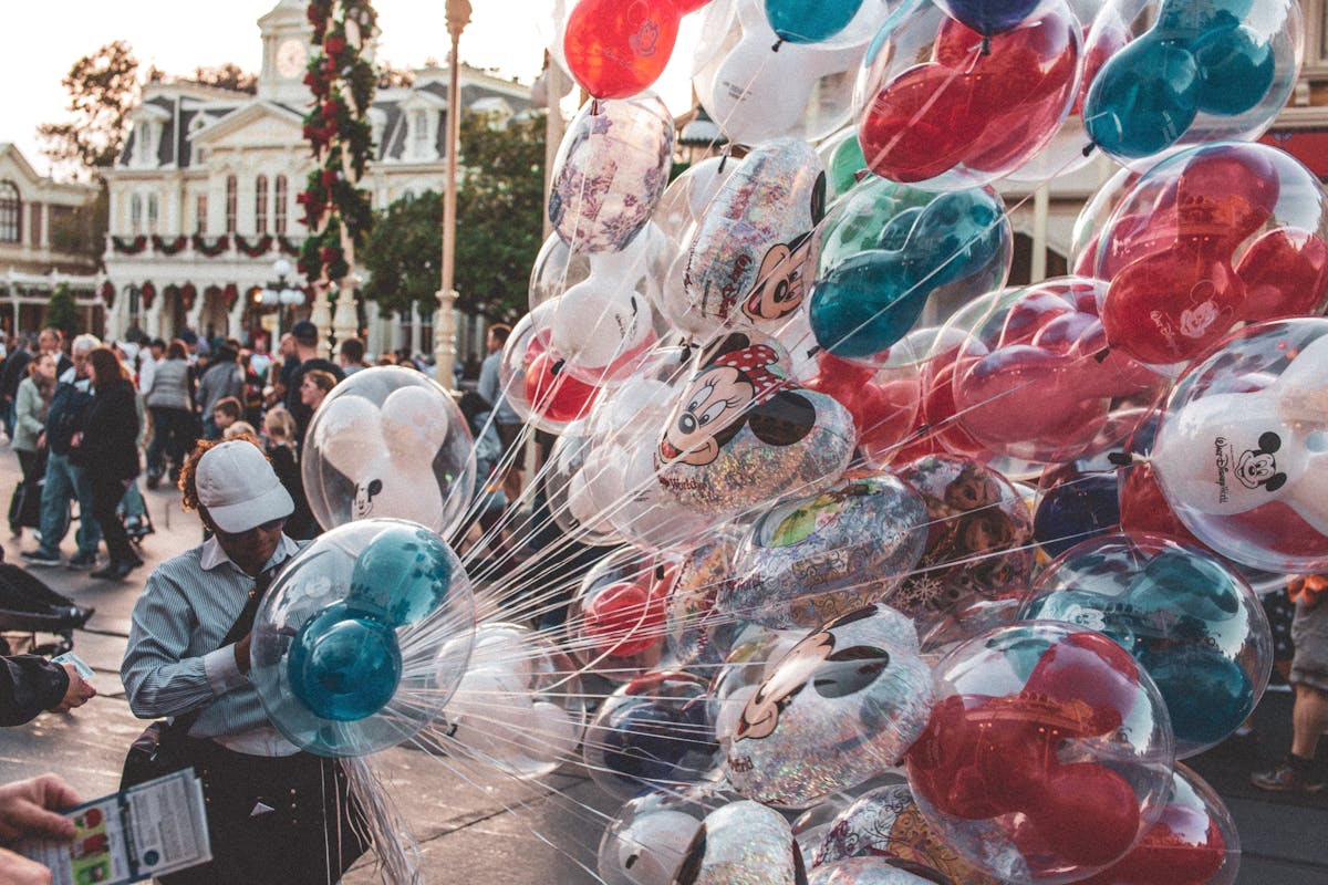 Colorful Disney balloons held by a guest at the theme park