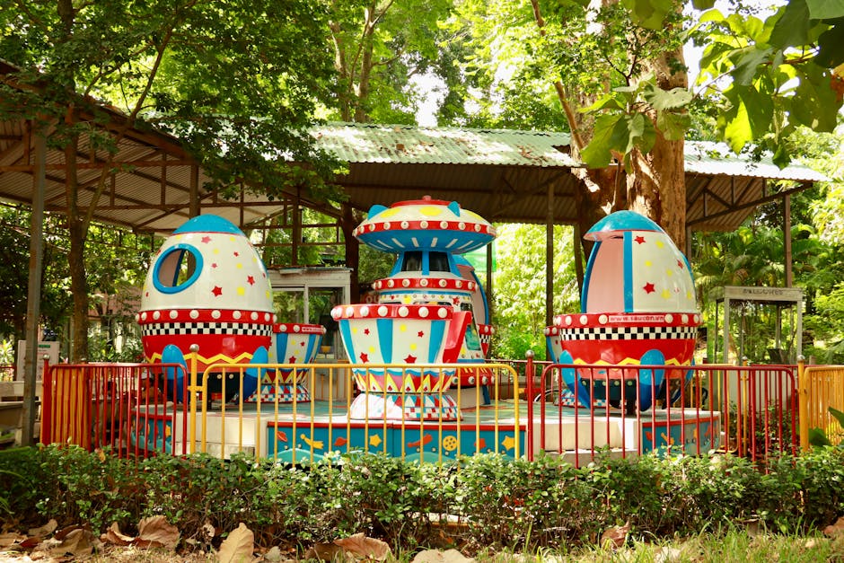 Colorful theme park ride surrounded by lush greenery at a family park