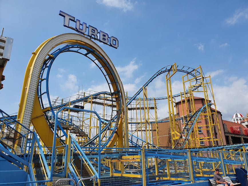 Colorful roller coaster at a theme park against a clear blue sky