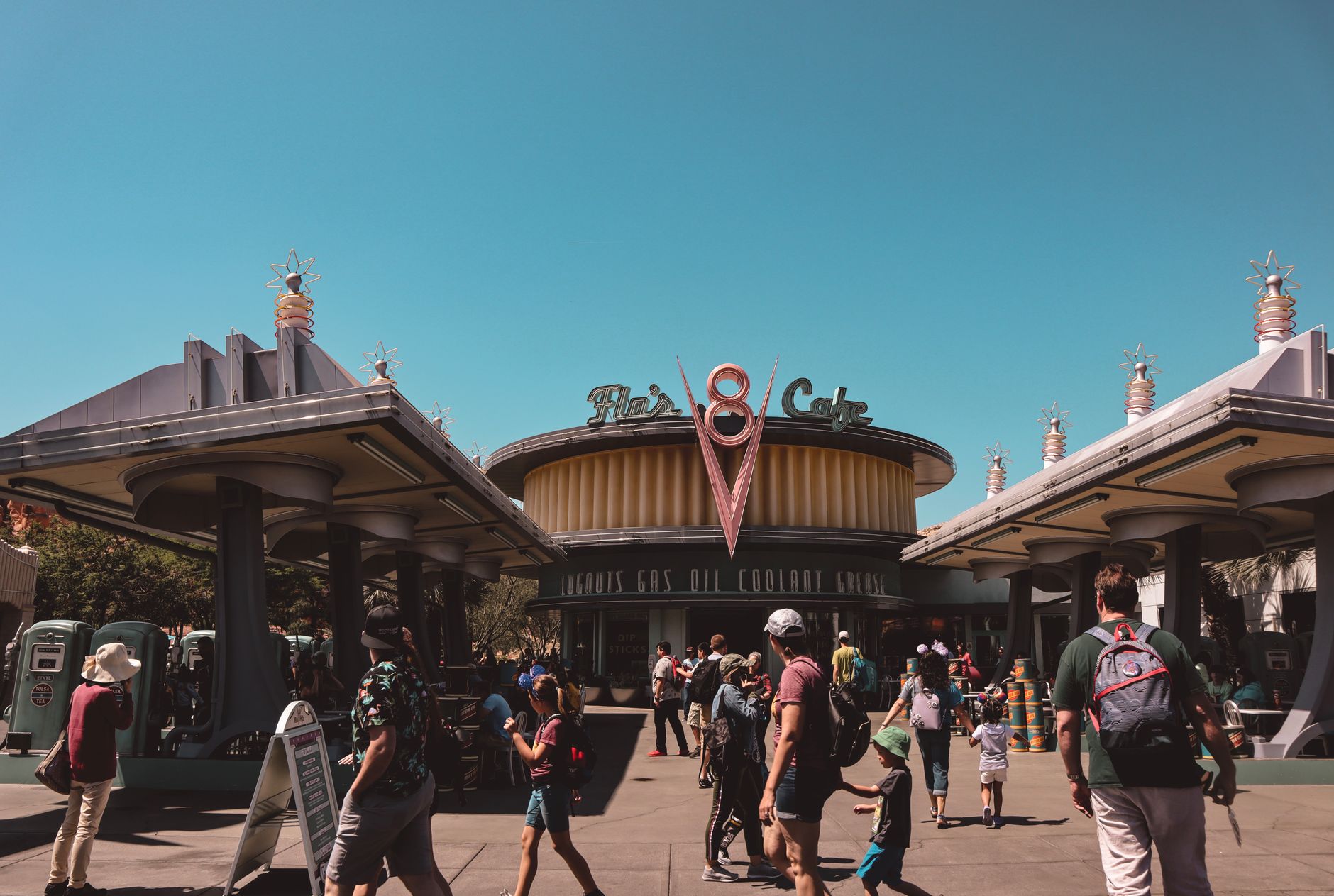 Families walking past Flo's V8 Cafe in Cars Land at Disney California Adventure Park, Anaheim, on a sunny day