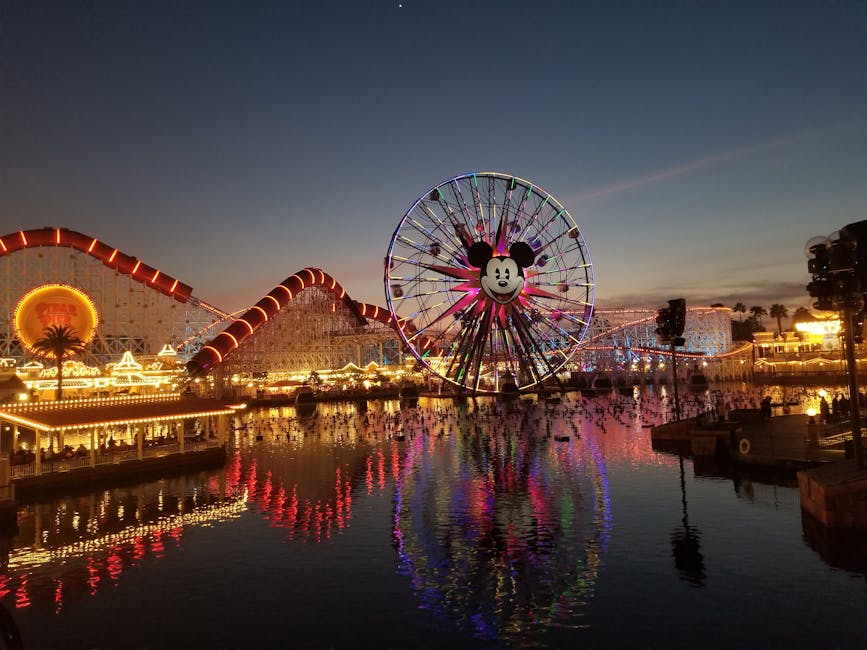 Lit-up Ferris wheel and rides at Disney California Adventure at twilight