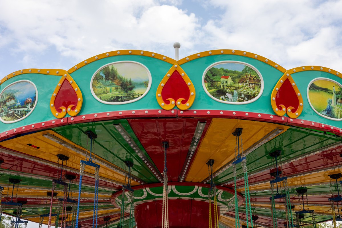 Brightly painted carousel under a clear sky, the gentler ride tier that fills a Dollywood day for younger children