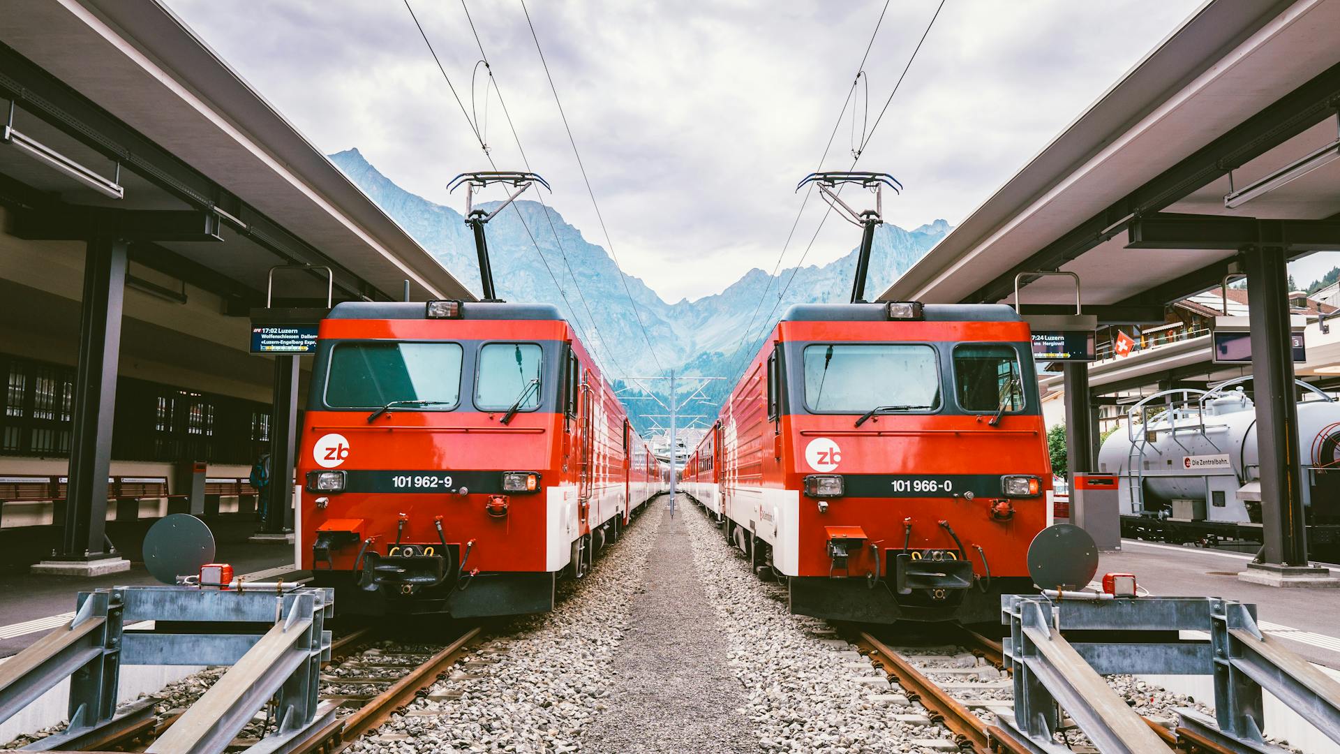 Red European trains at a station platform