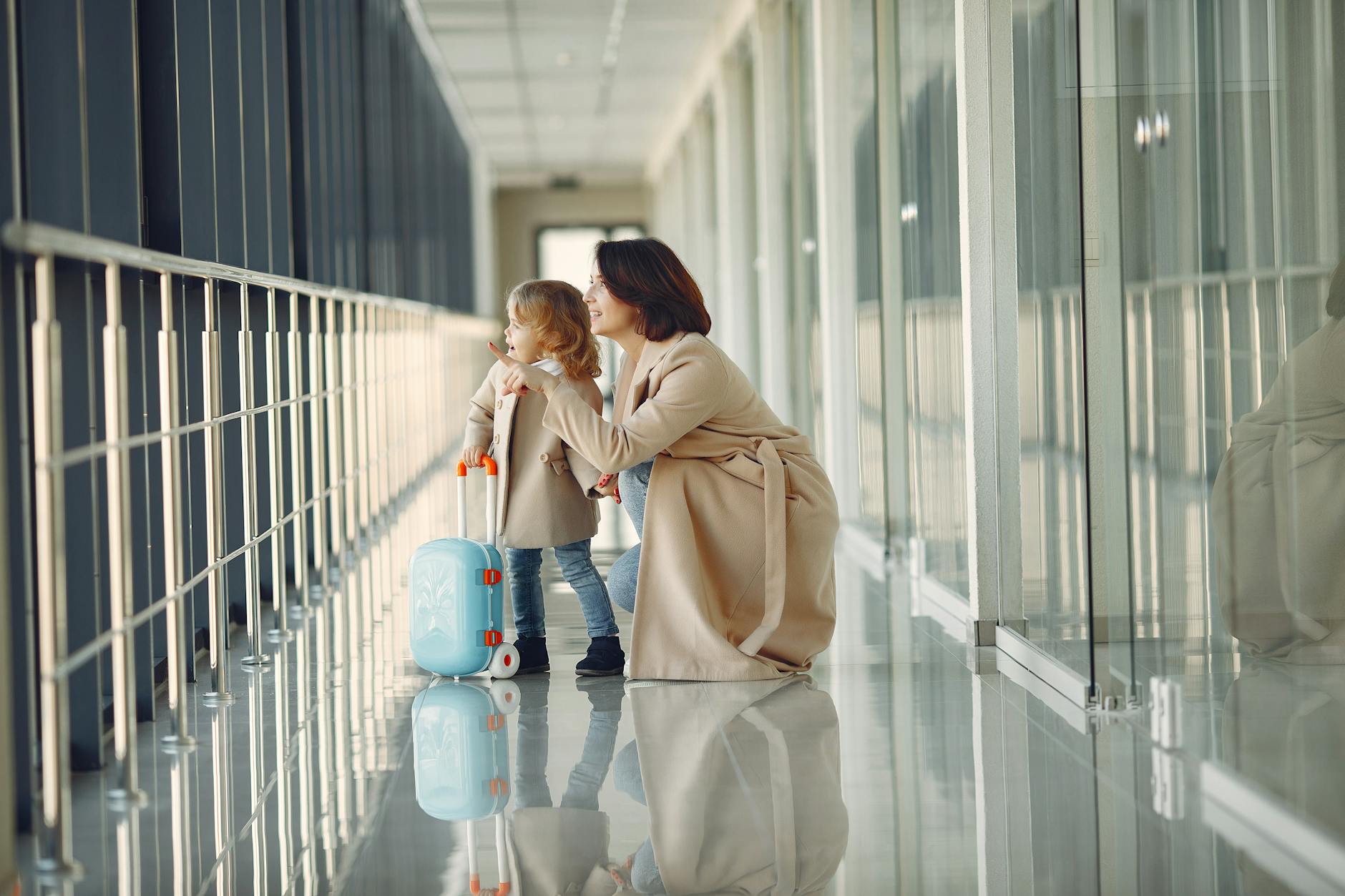 Mother and daughter walking through an airport corridor on departure day representing the fixed cost moment in family trip-length math