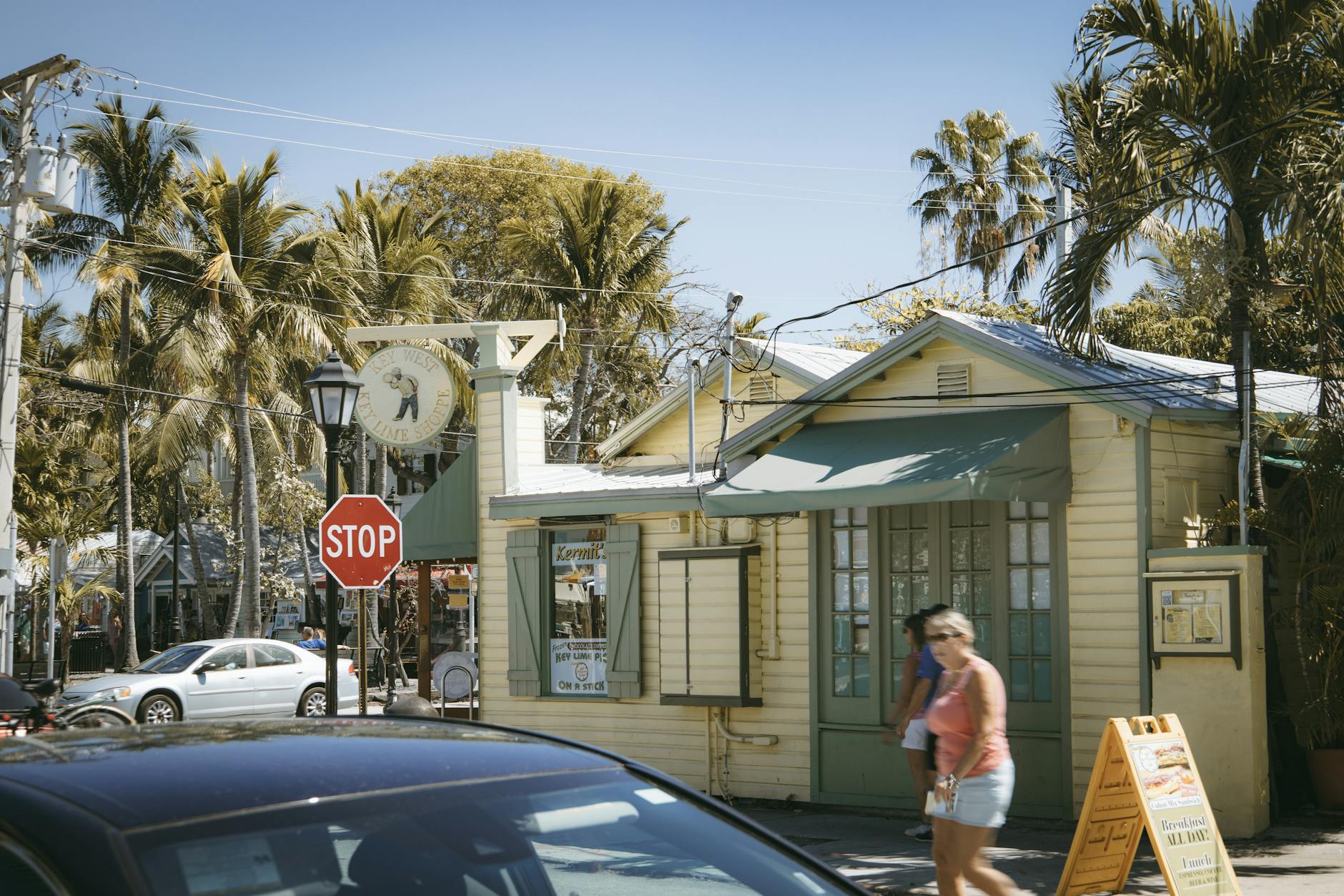 Palm-lined street scene in Key West Florida with colorful restaurant and blue sky