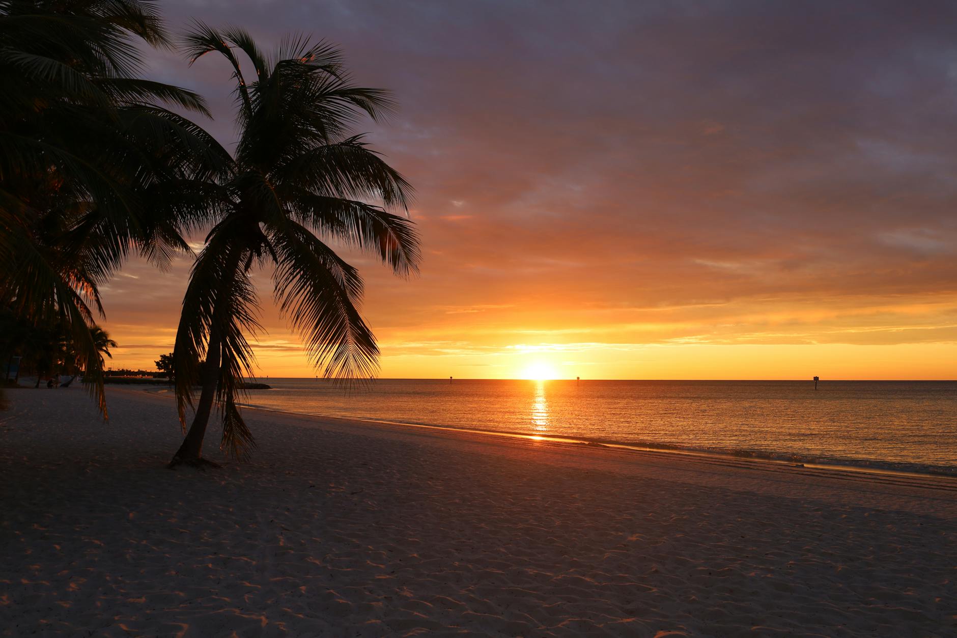 Sunset over tranquil sea at Key West beach with warm orange sky