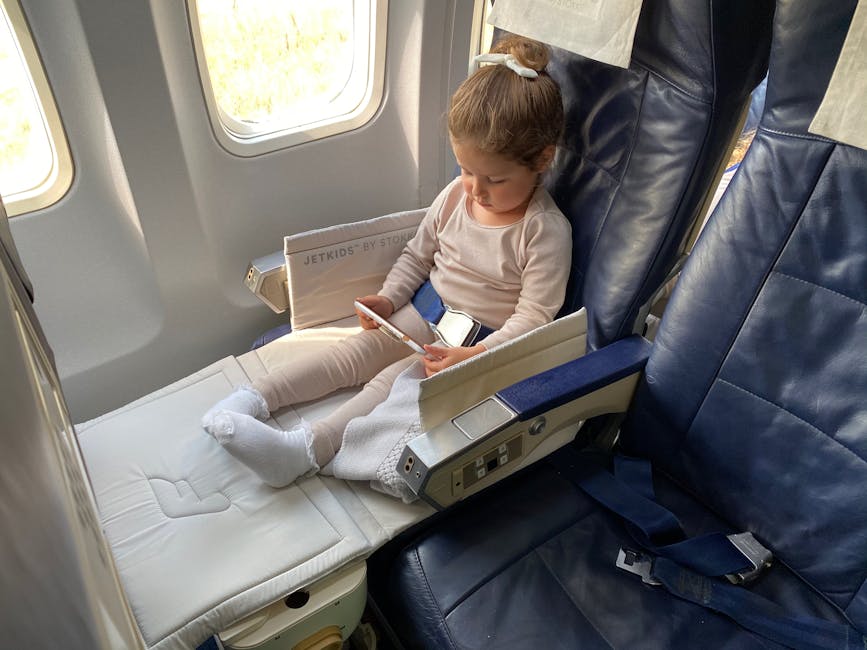 Young girl using a device while flying on an airplane