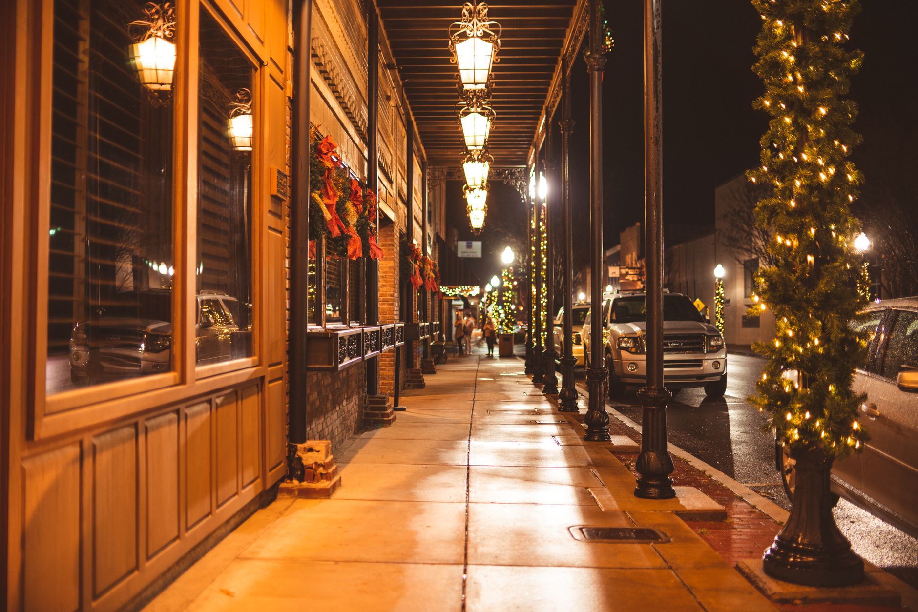 Downtown street glowing with holiday lights and lamps at night, the look of Gatlinburg's Winter Magic