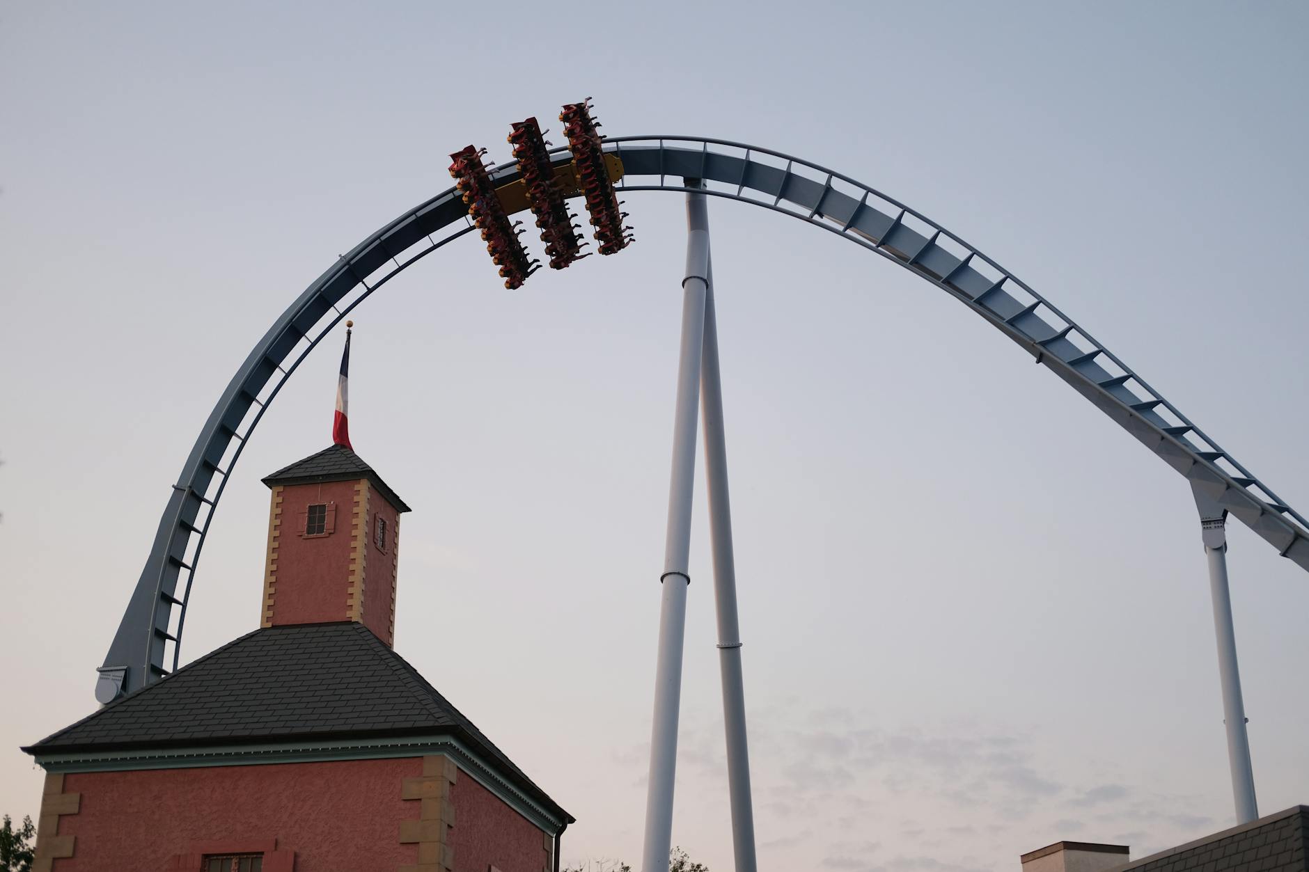 Roller coaster ascending at a theme park with sunset sky in the background