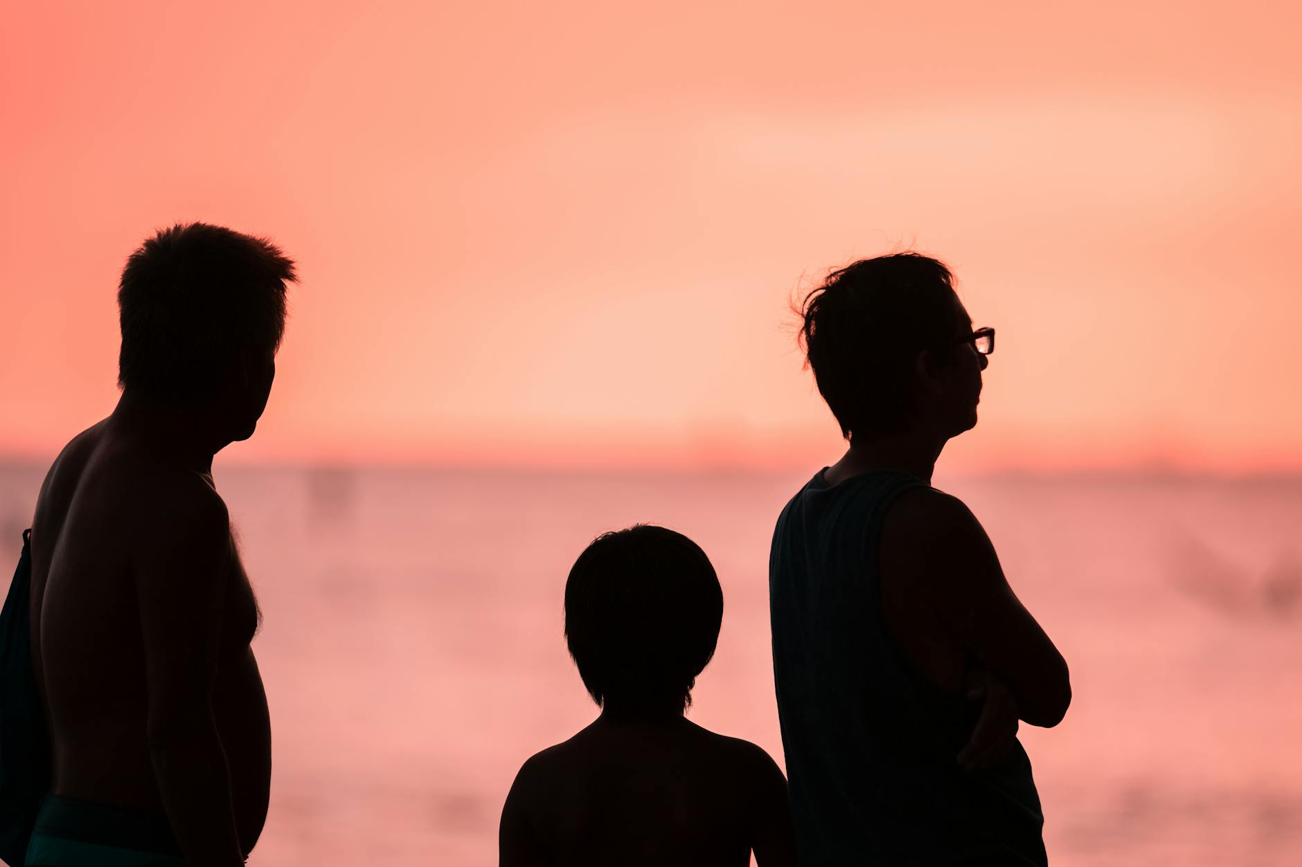 Silhouette of a family of three on a Hawaiian beach at sunset