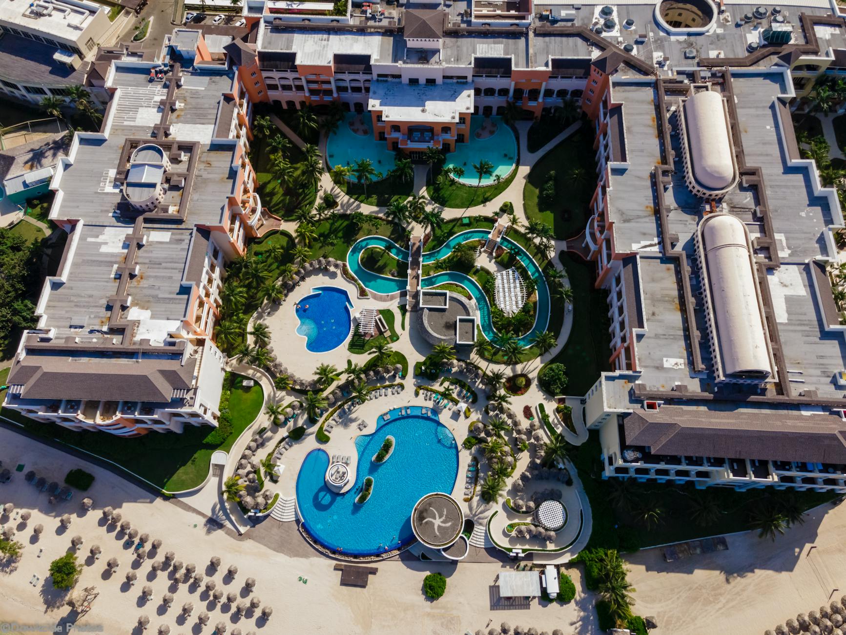 Aerial view of a Caribbean beachfront resort in Jamaica with pools and palm trees