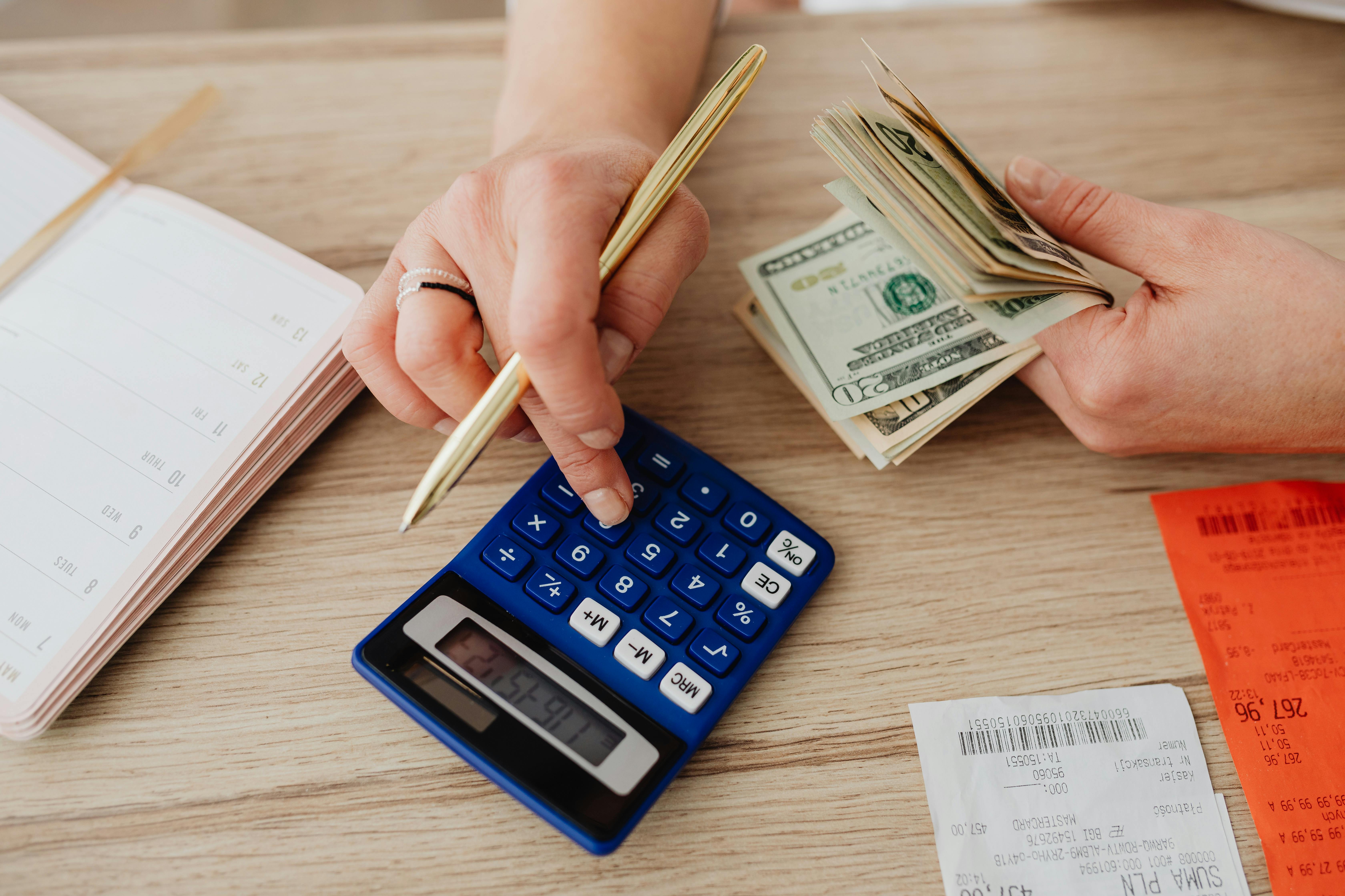 Family budgeting at the kitchen table with cash calculator and receipts before booking the vacation &mdash; the planning moment this guide addresses