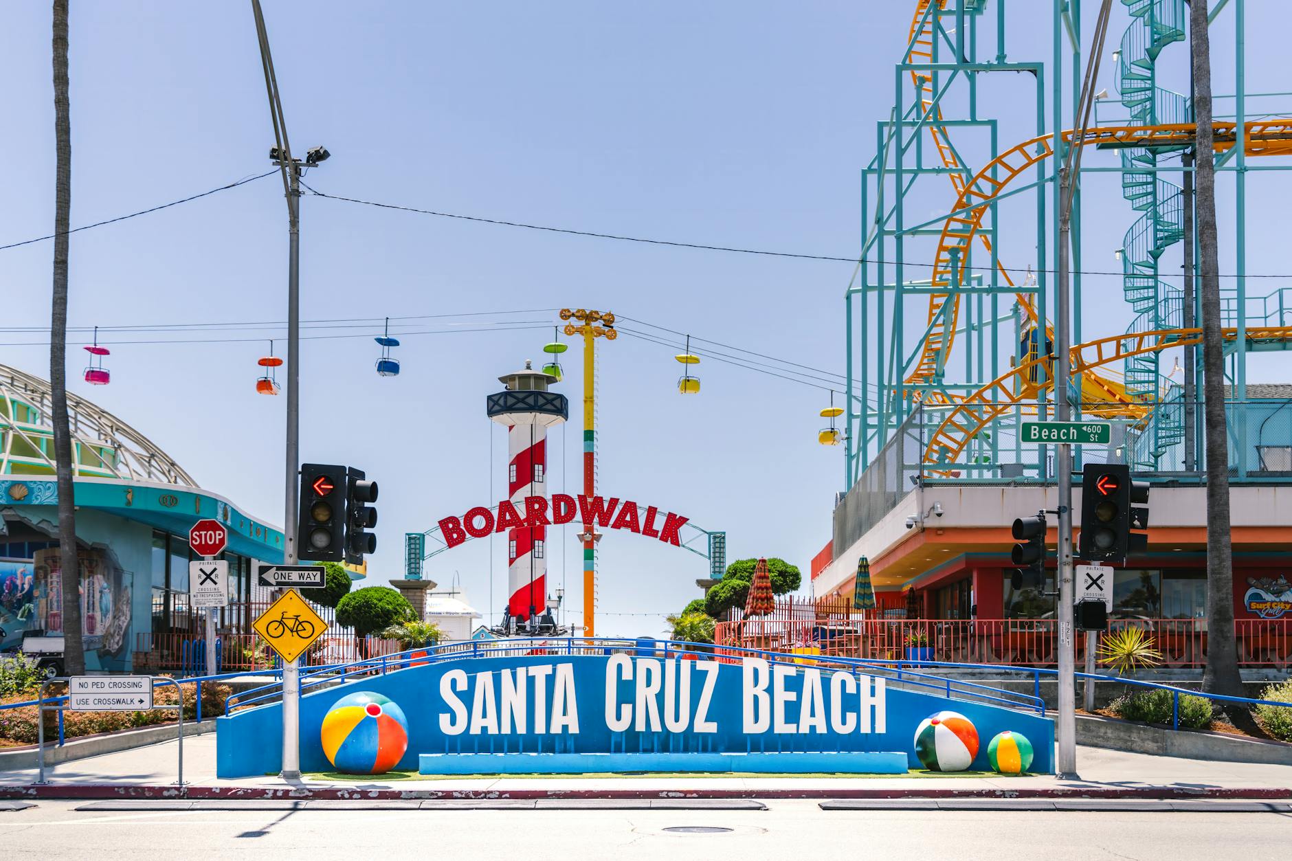 Colorful beach boardwalk entrance with amusement rides on a sunny summer day