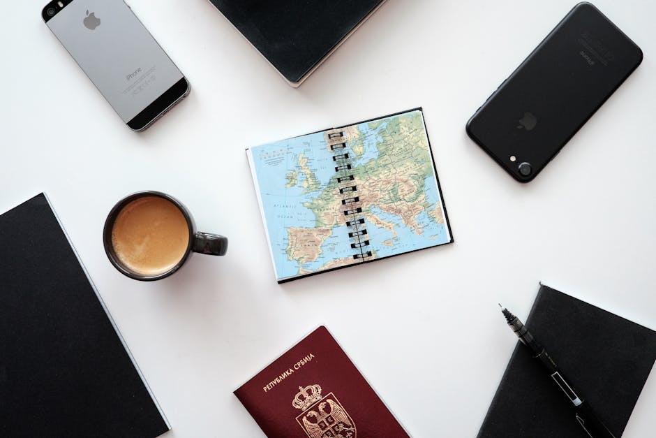 Travel planning flat lay with map, passport, and devices for family trip organization