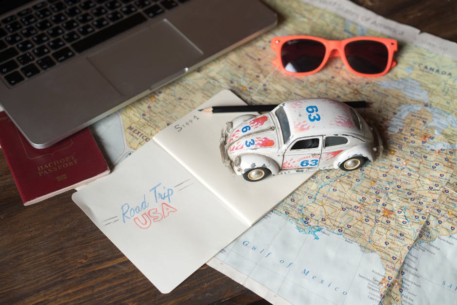 Flat lay of road trip planning with toy car, maps, and passport for family travel