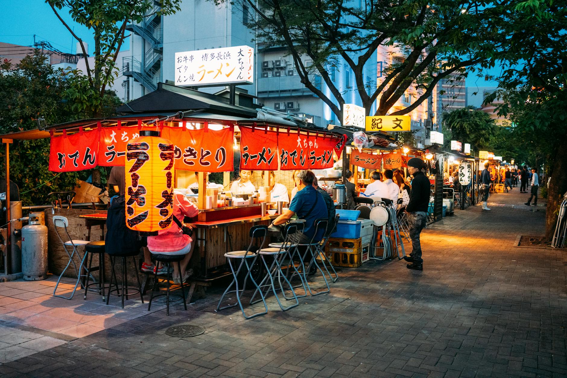 Japanese street food restaurants in Japan with illuminated stalls at night