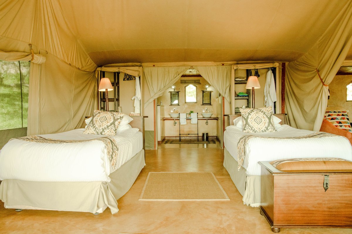 Safari-lodge styled twin-bed interior echoing the African theming Kalahari resorts carry through their suites