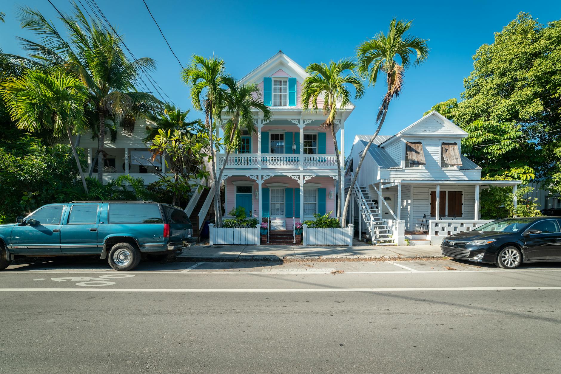 Colorful historic houses with palm trees along a sunny street in Key West Florida
