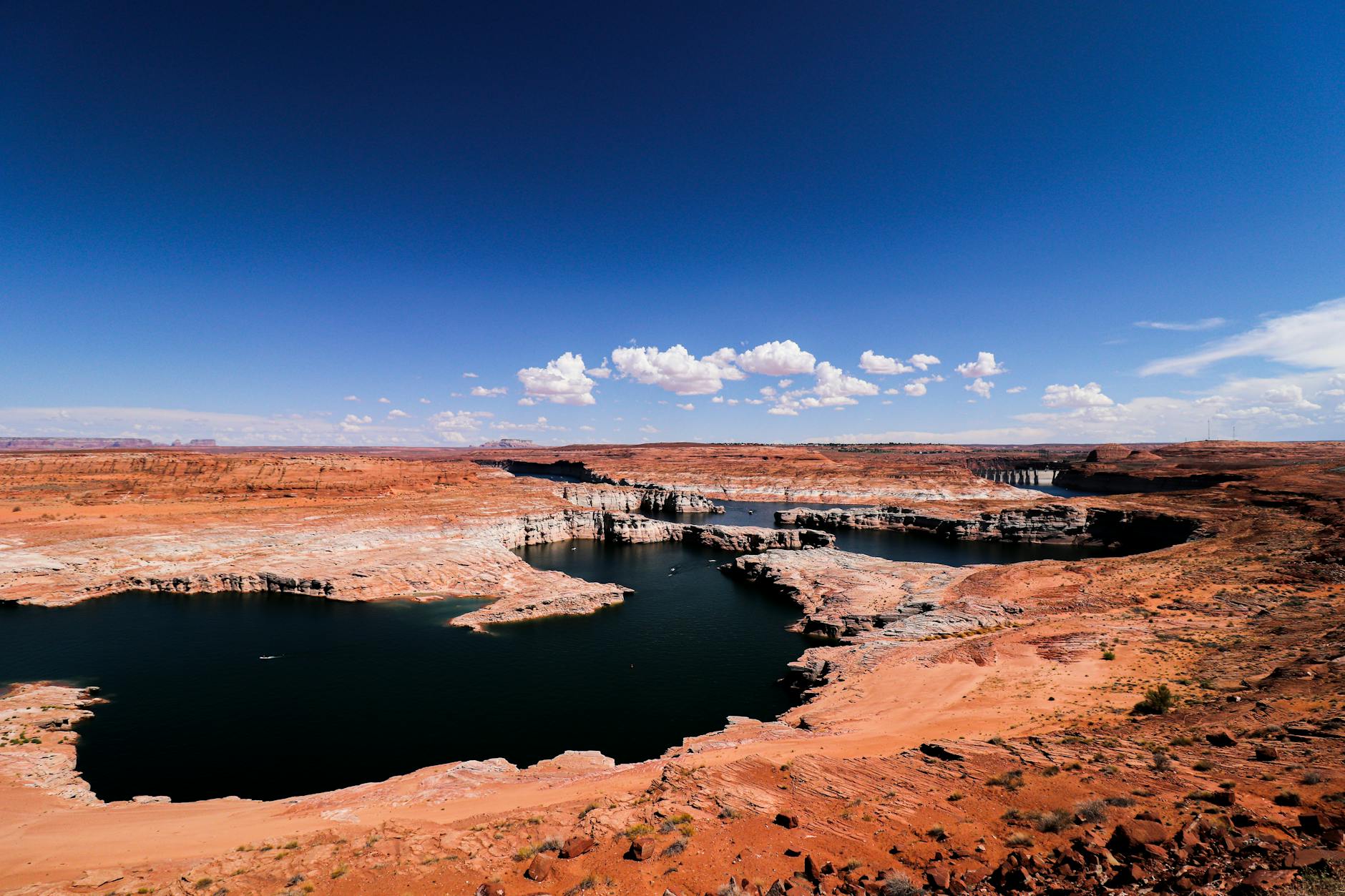 Aerial view of Lake Powell red rock formations and blue water stretching into canyons