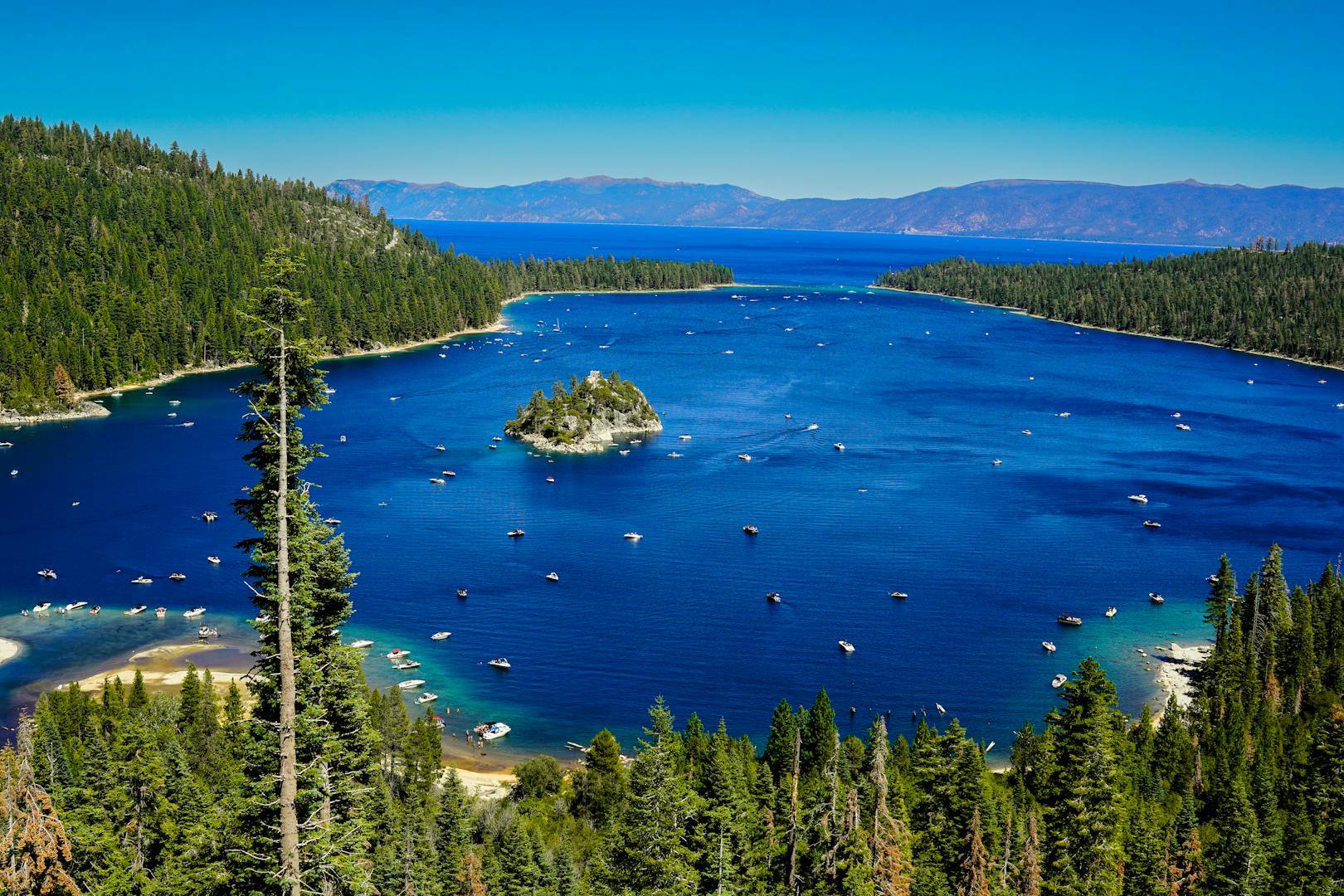 Family kayaking on calm turquoise Lake Tahoe water with mountain backdrop